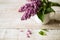 Purple lilac bouquet laid on wooden table. Studio shot.