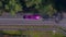 Purple limousine driving fast along the forest road. colored long car, highway