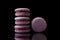 Purple macaroon cookies on a black background