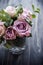 Purple, mauve color fresh summer roses in vase with black tablet