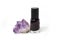 Purple nail polish bottle and amethyst stone isolated on white background