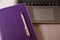 purple notepad, laptop and pink pen