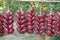 Purple onions hanging on ropes on a street market at the south of Ukraine