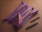 Purple origami paper and pen on wooden background. generative ai