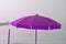 a purple parasol, open in front of the sea