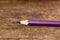 Purple pencil on old wooden table