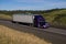 Purple Peterbilt Semi-Truck / White Trailer