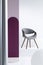 Purple pillar next to a gray chair in bright apartment