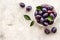 Purple plums in bowl. Plum harvest top view