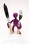 Purple puppet of plasticine standing behind plate