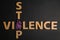 Purple ribbon and phrase STOP VIOLENCE on black, flat lay
