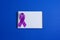 Purple ribbons and open notebook on blue background, Alzheimer disease, Pancreatic cancer, Epilepsy awareness, domestic violence