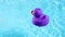 A purple rubber duck swims and drifts