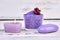 Purple salt with soap and candle on white background.