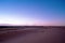 Purple sand dunes in the desert at nightfall.