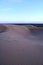 Purple sand dunes in the desert at nightfall.