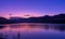 Purple sky at sunset over mountain and lake landscape