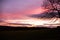 A purple sky sunset over a silhouetted countryside with power pylons