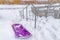 Purple sled beside an outdoor stairs in winter