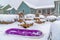 Purple sled and wooden chairs surrounded by snow during winter in Daybreak