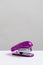 Purple stapler on gray background