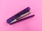 purple stapler on a pink background