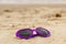 Purple sunglasses shaped heart on the sand