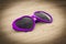 Purple sunglasses shaped heart on the sand