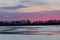 Purple sunrise along the Platte river in Nebraska with the silhouette of distant birds in flight