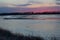 Purple sunrise along the Platte river in Nebraska with the silhouette of distant birds in flight