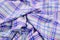 Purple tartan pattern on crumpled fabric.
