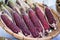 Purple waxy corn in basket on white background.