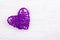 Purple wicker heart on a white wooden background. Eco Valentine. Heart of vines.