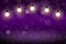 Purple wonderful shining glitter lights defocused bokeh abstract background with light bulbs and falling snow flakes fly, festal