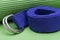 Purple Yoga Strap on Green Yoga Mat. Exercises for beginners