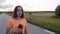 Purposeful,, young girl stands on a path and drinks from sport flask in morning