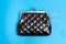 Purse for coins. Black leather wallet on blue background
