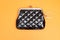 Purse for coins. Black leather wallet on orange background