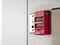 Push button switch, fire alarm on grey wall for alarm and security system with fire extinguisher port