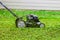 Push lawnmower in action with grass flying around/ Lawncare concept