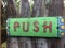 Push sign colorful painted green wooden sign on a distressed fence