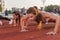 Push-ups athlete fitness women exercising in stadium. Training outdoors