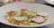 Put chicken slices over fusilli in white plate closeup