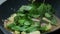 Put herbal green sweet basil leaves into the black teflon pan