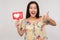 Put Like to social media content! Joyful enthusiastic asian girl showing internet heart icon and gesturing thumb up