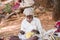 PUTTAPARTHI, ANDHRA PRADESH, INDIA - JULY 9, 2017: Rustic old man in a traditional white dress with a fishing net. Close-up.