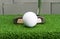 Putter address at golf ball on artificial grass.