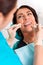 Putting dental braces to the woman`s teeth at the dental office. Dentist examine female patient with braces in dental