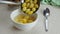 Putting ginkgo seeds in syrup into white ceramic bowl.