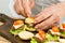 Putting on a toothpick on burger. Step by step preparation of mini burgers. Homemade mini burgers for children or appetizers.